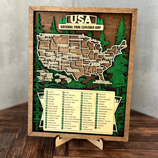 A framed wooden USA National Park Explorer Map display on a small easel stand, set on a dark wood tabletop against a light gray wall.